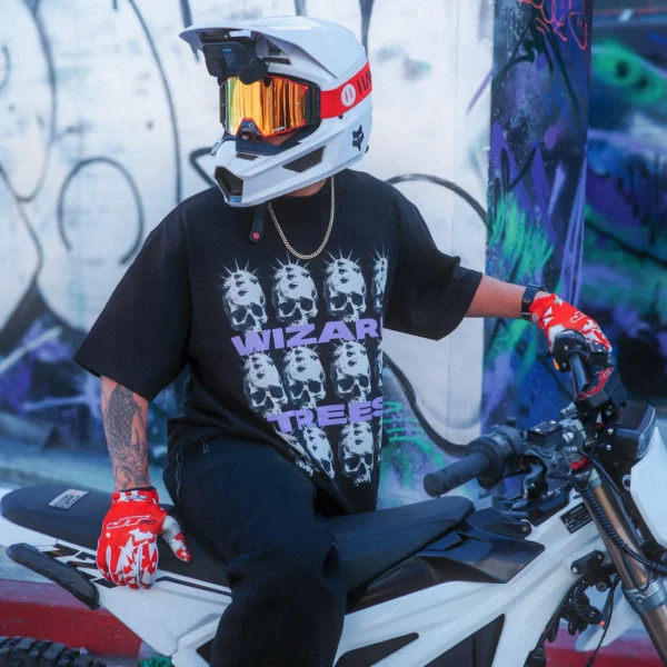 Model wearing the Skulls Tee while seated on a dirt bike