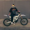 Model wearing the Wizard Band Tee while sitting on a dirt bike