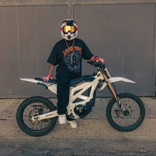 Model wearing the Wizard Band Tee while sitting on a dirt bike